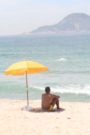 Man sitting under a beach umbrella