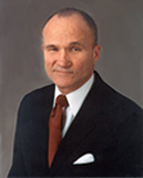 Raymond W. Kelly is seen here wearing a handkerchief in his left-breast pocket.  This is  a very common addition to a suit.